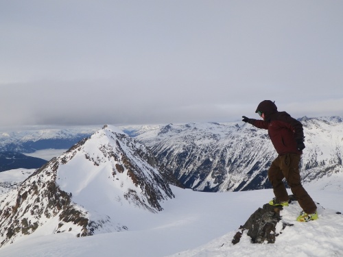 James on the summit of whirlwind, pointing towards Fissile Peak.